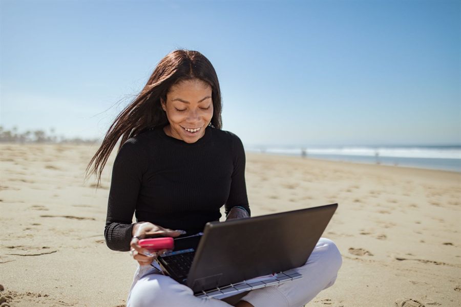 Woman on a beach with a laptop